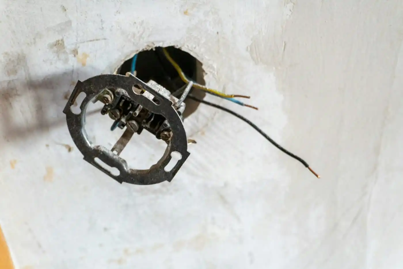 Wall socket being fitted, with its wiring coming out of the box in the wall